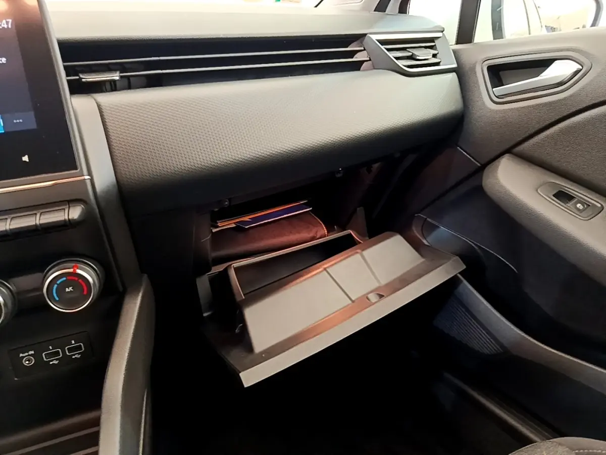 Vue intérieure côté passager de la Renault Clio Business Blue dCi 85 2020, boîte à gants ouverte et tableau de bord noir.