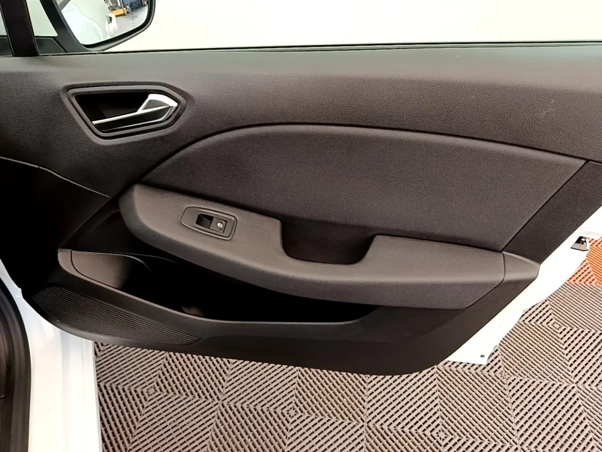 Vue intérieure de la porte avant gauche d'une Renault Clio Business Blue dCi 85 blanche, avec poignée et commande de vitre noire.