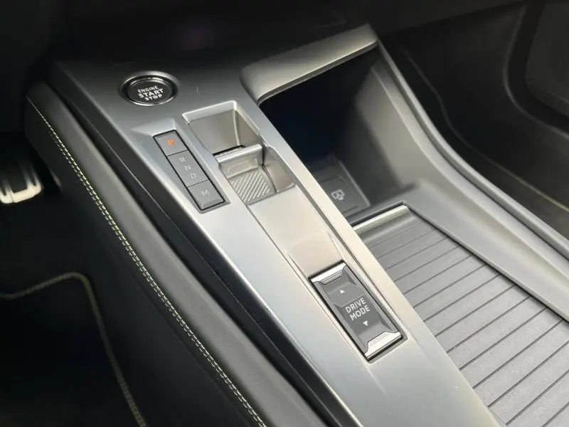 Vue rapprochée de la console centrale de la Peugeot 308 SW 2023 avec levier de vitesses automatique et bouton Drive Mode.