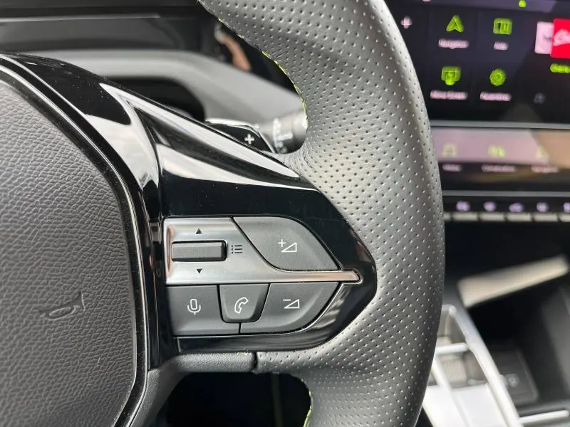 Gros plan sur les commandes du volant côté gauche en cuir perforé de la Peugeot 308 SW Bleu Avatar 2023.