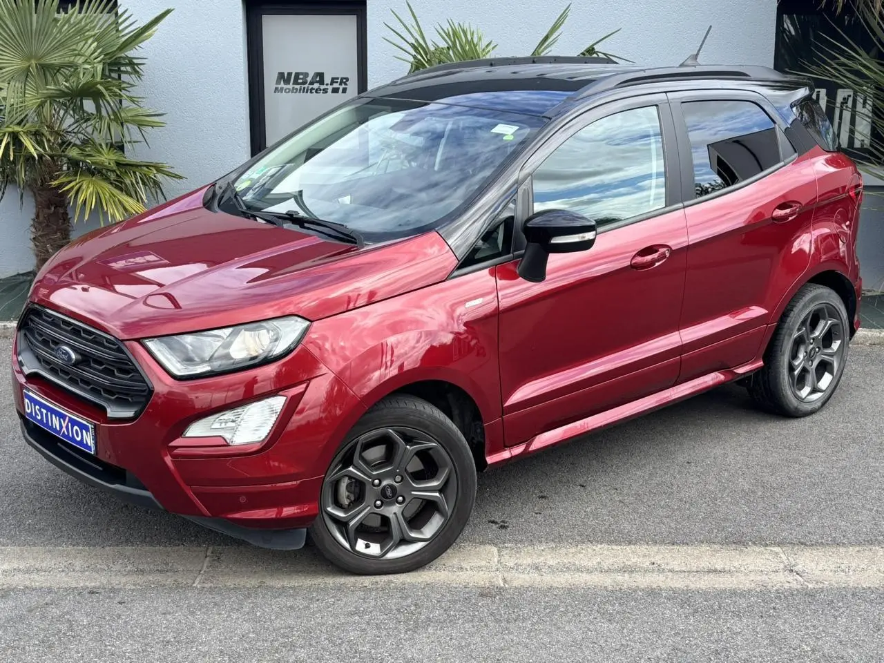 Ford EcoSport rouge métallisé en 3/4 avant droit avec toit noir et jantes alliage 17 pouces.