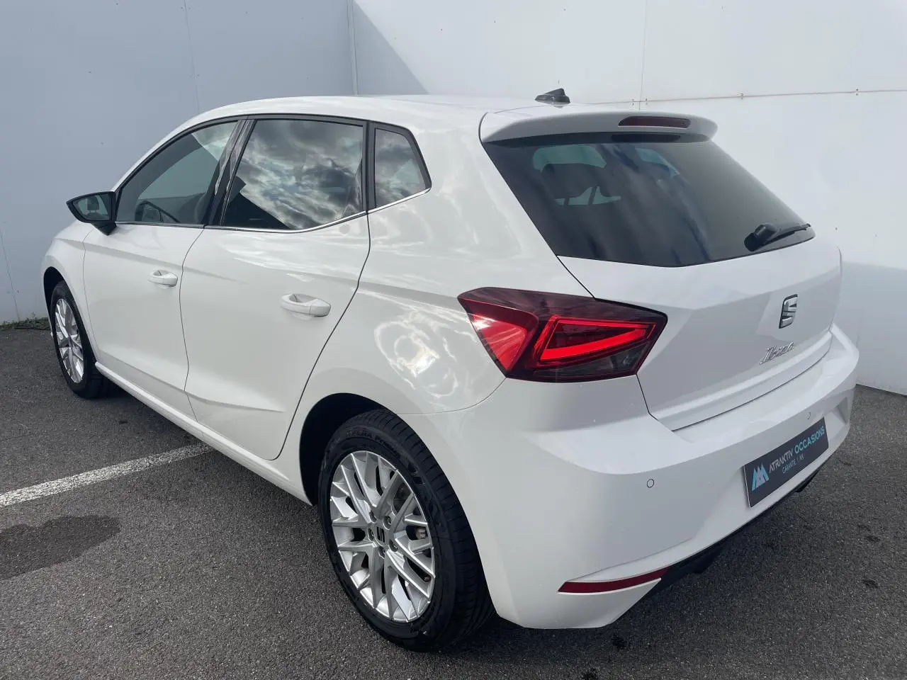 SEAT Ibiza blanche vue en 3/4 arrière droit, avec feux LED triangulaires et jantes alliage 16 pouces.