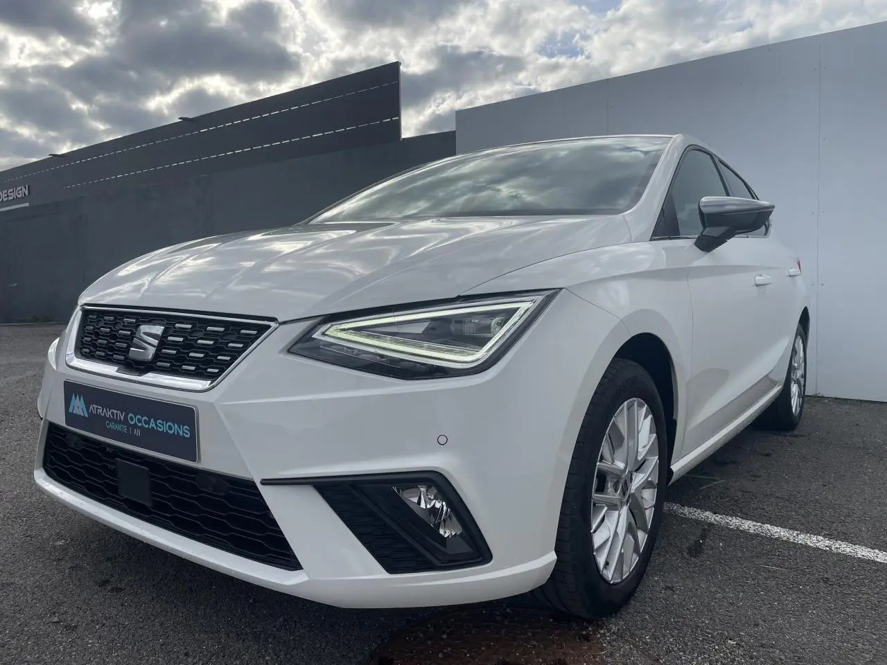 SEAT Ibiza blanche vue en 3/4 avant droit, avec phares LED triangulaires et jantes alliage 16 pouces.