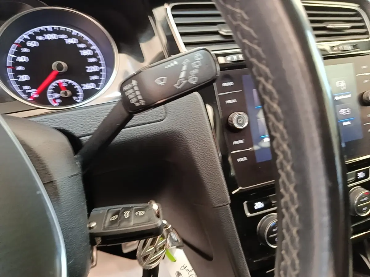 Gros plan sur le volant cuir et tableau de bord noir de la Volkswagen Golf 2020 avec écran tactile et commandes multifonctions.