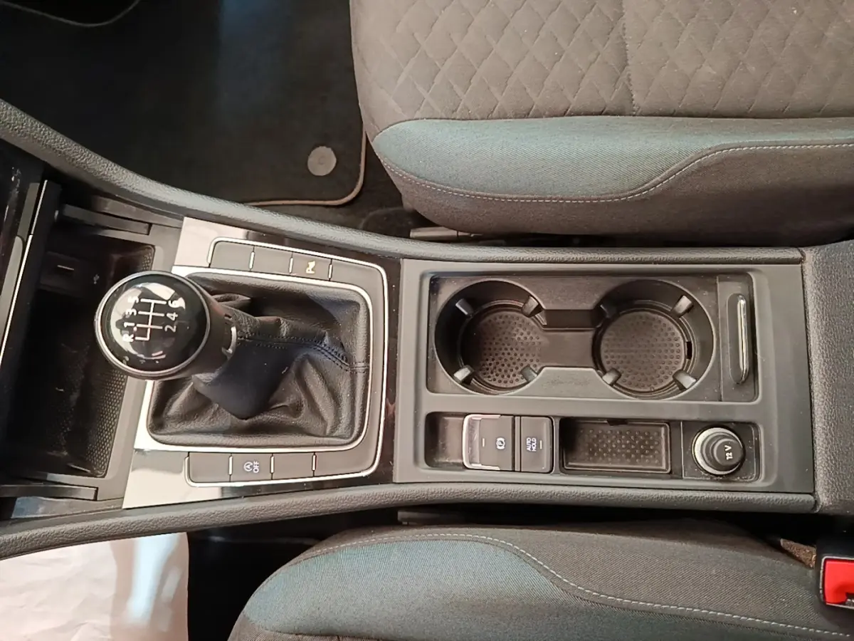 Vue plongeante sur la console centrale de la Volkswagen Golf 1.0 TSI 115 BVM6 avec levier de vitesse manuel et porte-gobelets.