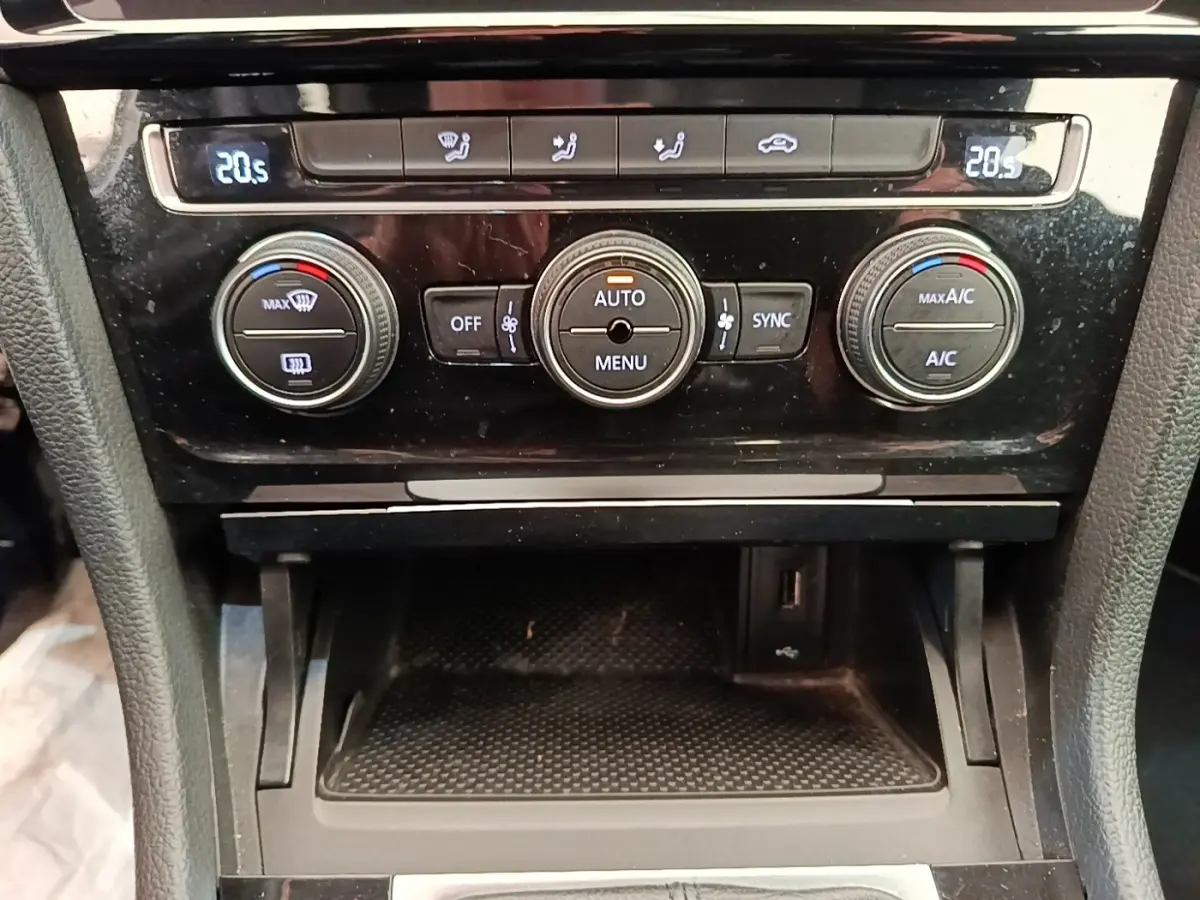 Vue rapprochée de la console centrale de la Volkswagen Golf 2020, avec commandes de climatisation digitales affichant 20,5°C.