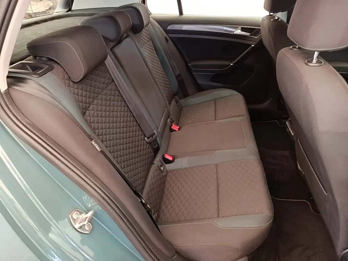 Vue intérieure côté gauche sur la banquette arrière en tissu noir de la Volkswagen Golf bleu 2020.