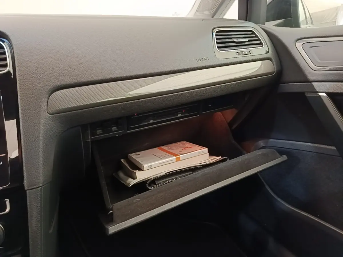 Intérieur de la Volkswagen Golf 1.0 TSI 115 BVM6 IQ.DRIVE 2020, vue sur boîte à gants ouverte avec documents visibles.