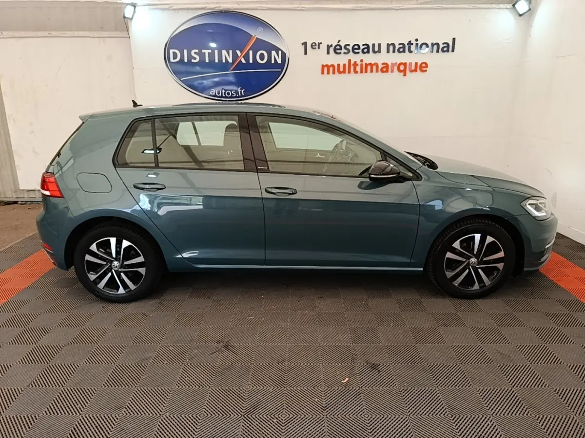Vue de profil côté gauche d'une Volkswagen Golf 1.0 TSI bleu, avec jantes alliage et rétroviseurs noirs.