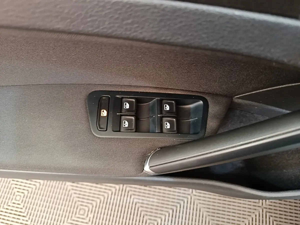 Gros plan sur les commandes des vitres électriques côté conducteur d'une Volkswagen Golf bleu 2020.