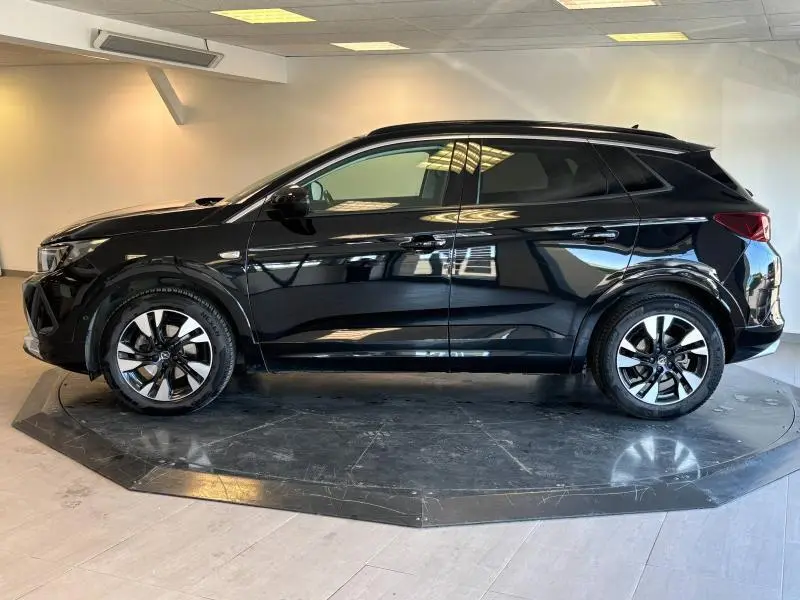 Profil droit d'un Opel Grandland noir diamant métallisé 2022, avec jantes alu bicolores et vitres surteintées.