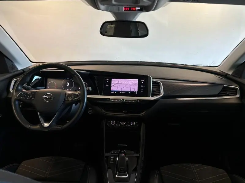 Vue intérieure avant de l'Opel Grandland noir Diamant, avec tableau de bord numérique et écran tactile GPS central.