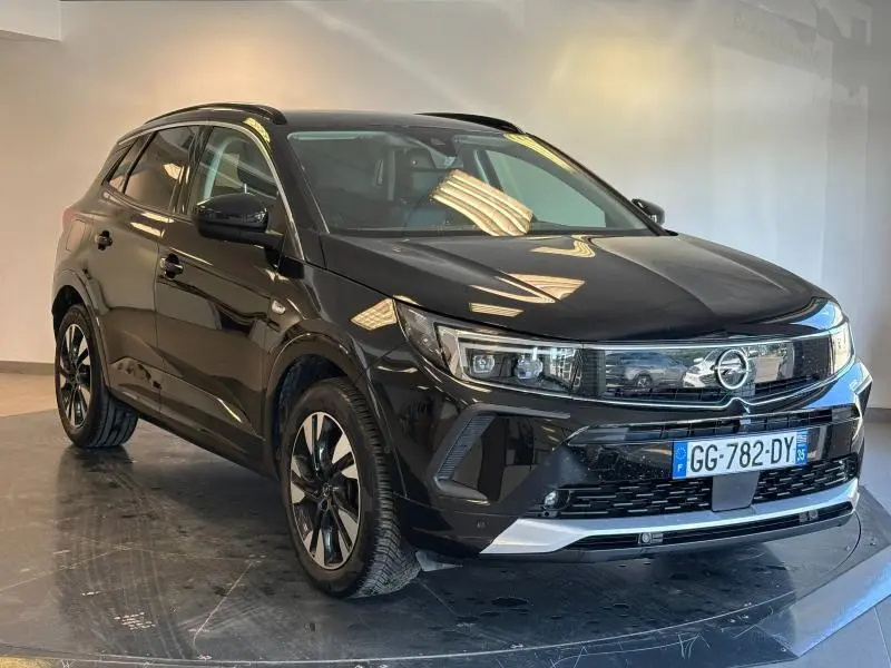 Opel Grandland noir diamant métallisé vu en 3/4 avant droit avec calandre chromée et jantes alu bicolores.