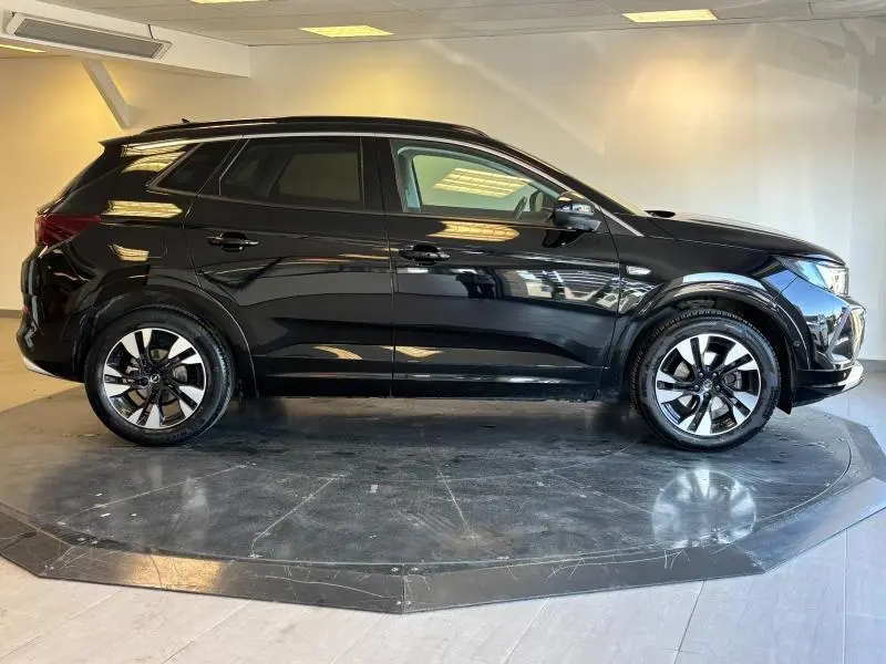 Vue latérale droite d'un Opel Grandland noir diamant métallisé avec jantes alliage et vitres surteintées.
