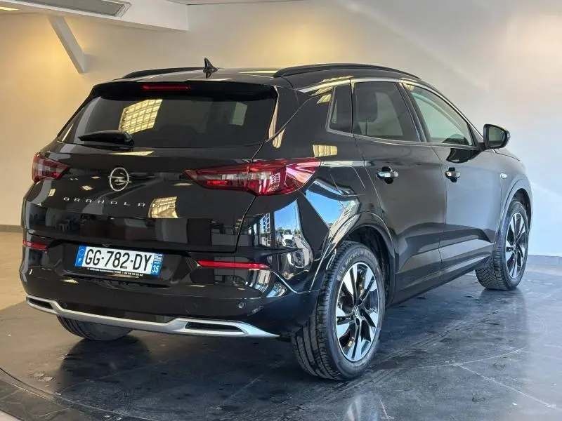 Opel Grandland noir diamant métallisé vu 3/4 arrière droit, avec jantes alliage et vitres surteintées.