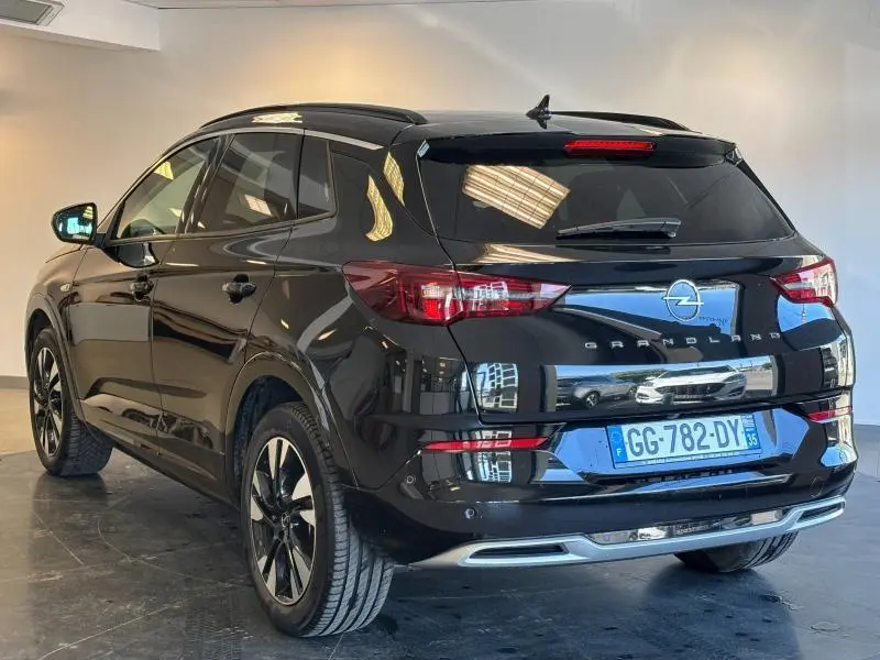 Opel Grandland noir diamant métallisé vu de 3/4 arrière droit avec feux LED et jantes alu noires et argentées.