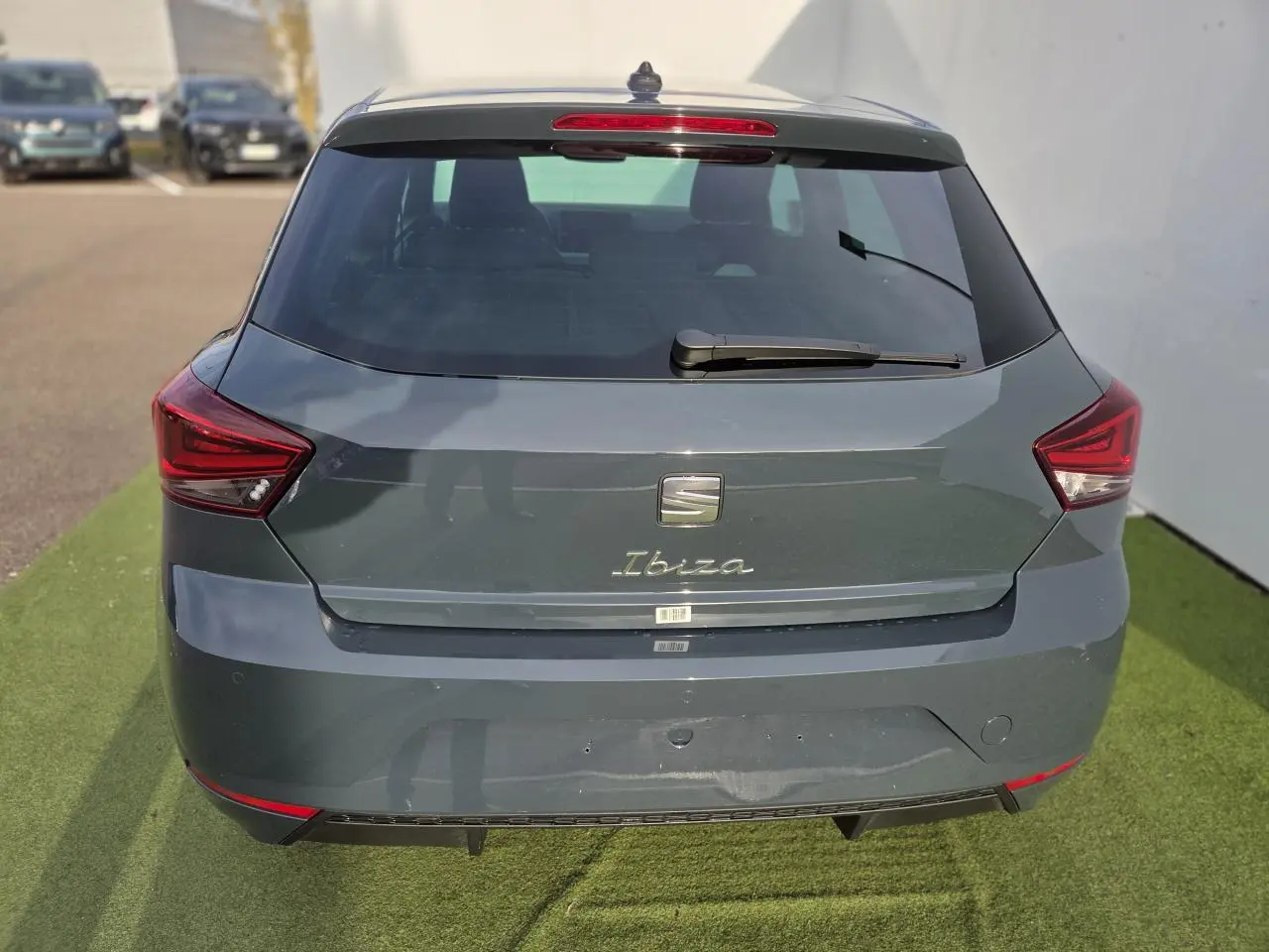 Vue arrière d'une SEAT Ibiza bleu Fjord métallisé avec feux LED triangulaires et lunette arrière teintée.