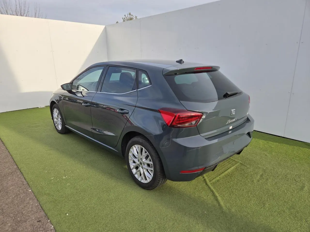 Vue 3/4 arrière droite d'une SEAT Ibiza 2025 bleu fjord métallisé avec jantes alliage et vitres teintées.