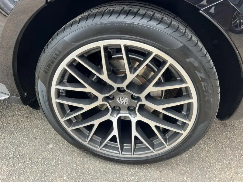 Gros plan sur la jante alu 21 pouces Sport Classic noire et argent du Porsche Macan noir 2018, pneu Pirelli P Zero visible.