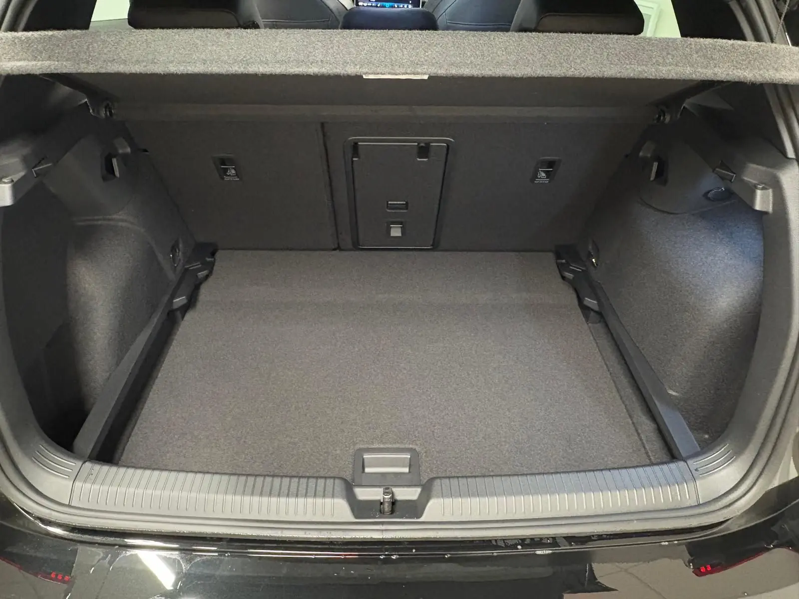 Vue arrière du coffre ouvert de la Volkswagen Golf 2.0 TDI noir grenadille, montrant un espace de chargement propre et spacieux.