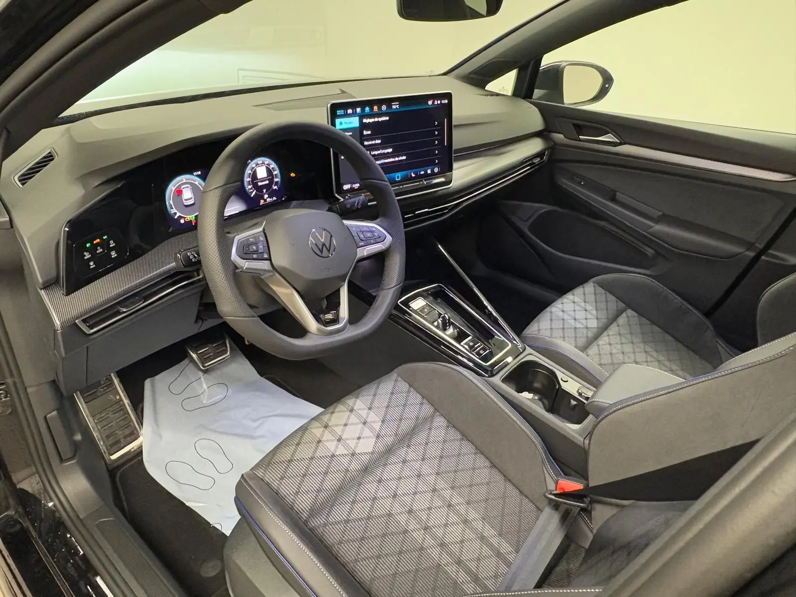 Vue intérieure côté conducteur de la Volkswagen Golf 2.0 TDI R-Line, avec volant cuir multifonction et écran tactile central.