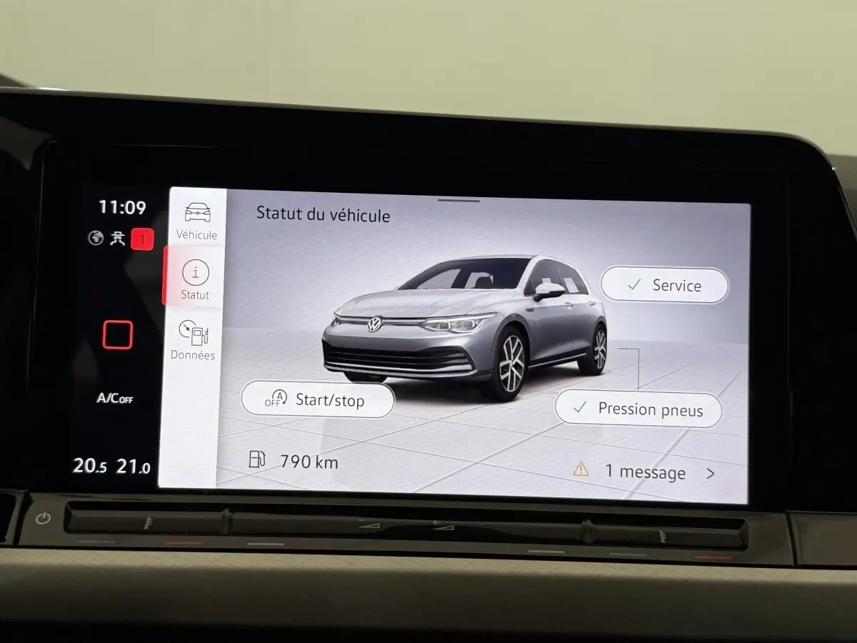Écran tactile affichant une Volkswagen Golf grise en 3/4 avant avec statut véhicule et options service et pression pneus.