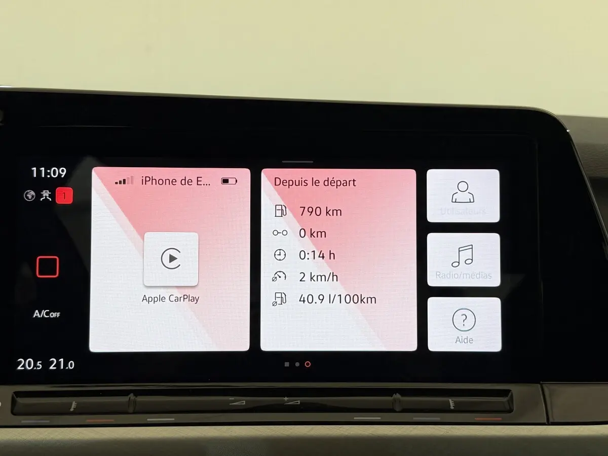 Écran tactile central de la Volkswagen Golf bleu 2021 affichant Apple CarPlay et données de trajet.