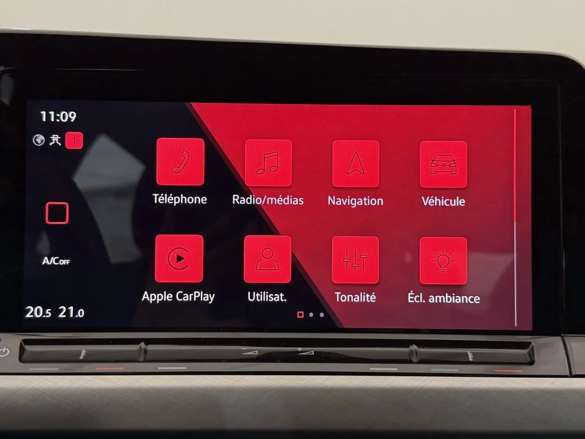 Écran tactile central de la Volkswagen Golf bleu 2021 affichant les menus téléphone, navigation et ambiance lumineuse.