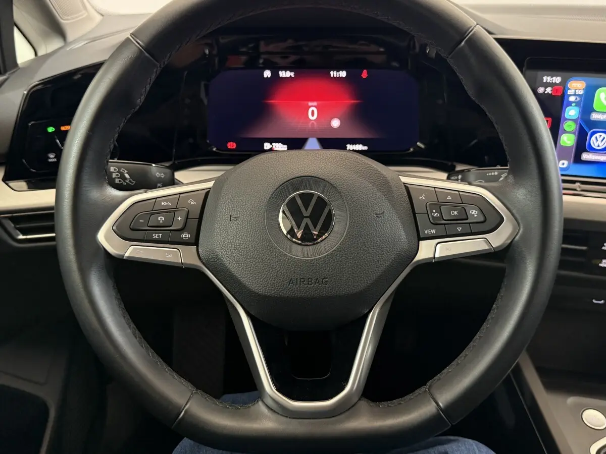 Vue rapprochée du volant cuir multifonctions d’une Volkswagen Golf 2.0 TDI 2021 avec tableau de bord digital et écran tactile.