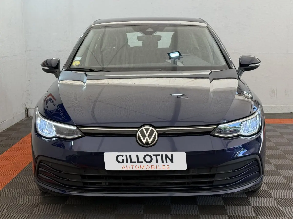 Vue avant d'une Volkswagen Golf 2.0 TDI bleu foncé avec phares LED allumés et calandre noire.