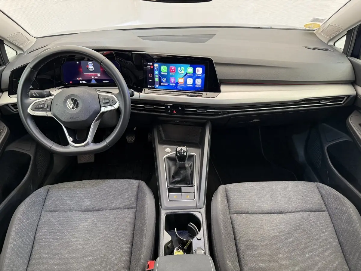Vue intérieure avant de la Volkswagen Golf 2.0 TDI bleue, avec tableau de bord numérique et boîte manuelle.