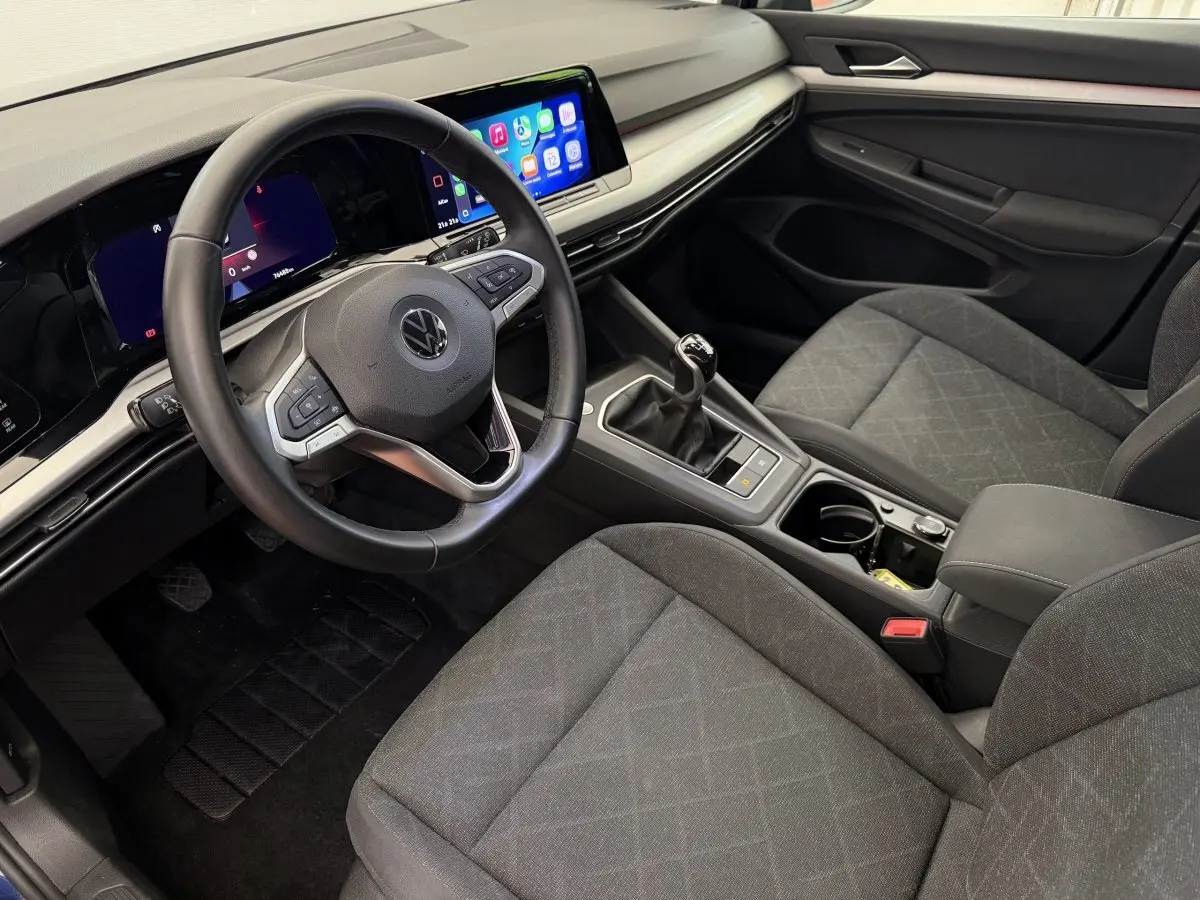Vue intérieure côté conducteur de la Volkswagen Golf 2.0 TDI 2021 avec tableau de bord numérique et écran tactile couleur.
