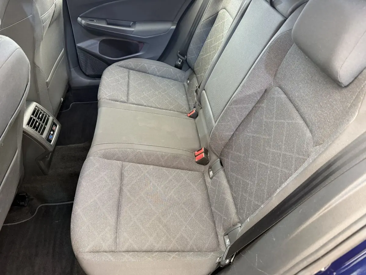 Vue côté droit de la banquette arrière grise à motifs de la Volkswagen Golf 2.0 TDI Life avec aérateurs et ceintures visibles.