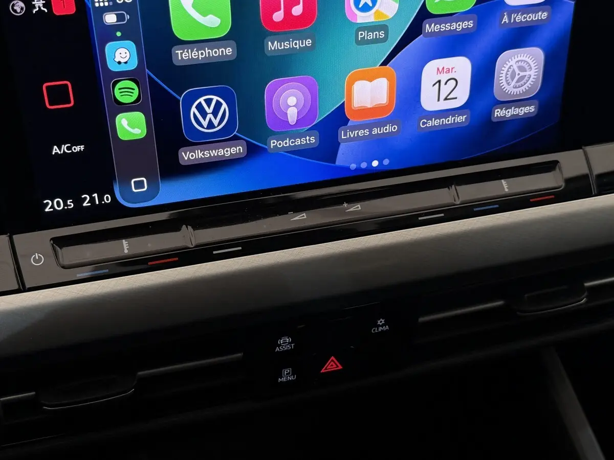 Détail de l’écran tactile central avec commandes climatisation et interface Apple CarPlay dans Volkswagen Golf bleu 2021.
