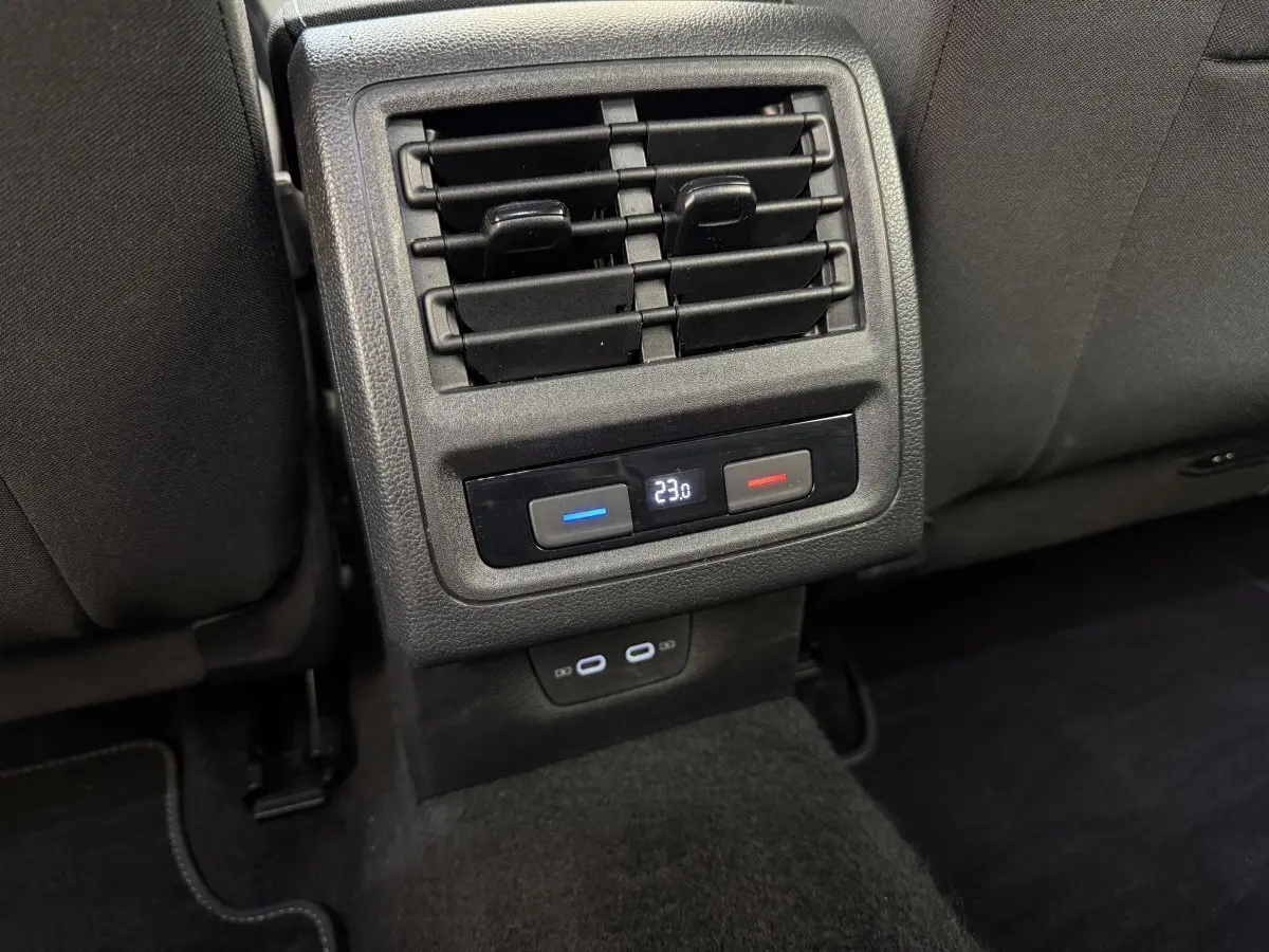 Détail des commandes de climatisation arrière et prises USB dans l’habitacle noir d’une Volkswagen Golf bleue.