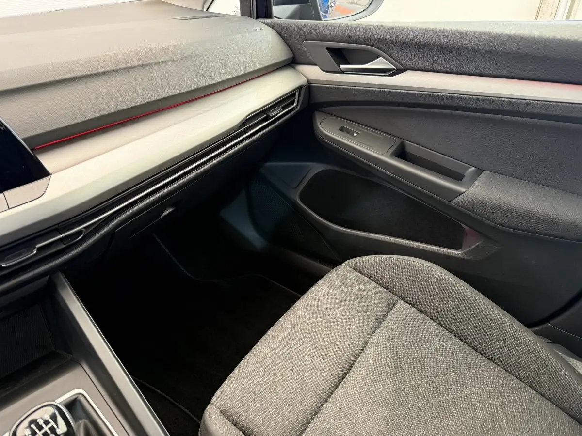 Vue intérieure côté passager de la Volkswagen Golf 2.0 TDI Life 2021 avec tableau de bord noir et siège tissu gris.