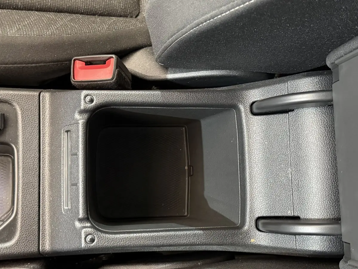 Vide-poche central et frein à main manuel dans l'habitacle d'une Volkswagen Golf 2.0 TDI bleu, vue rapprochée intérieure.