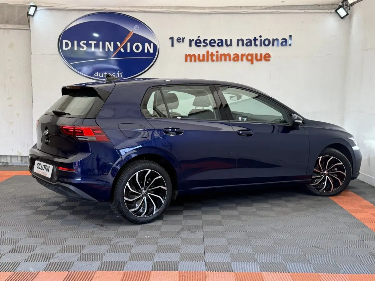 Vue latérale droite d'une Volkswagen Golf 2.0 TDI bleu foncé avec jantes alliage et feux arrière LED visibles.
