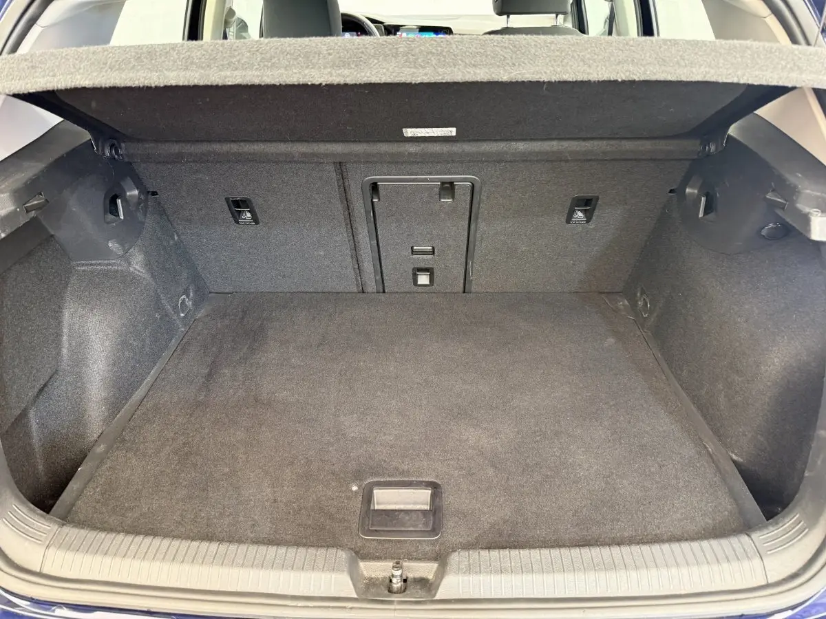 Coffre ouvert de la Volkswagen Golf bleu, vue de l'arrière montrant un espace de chargement propre et spacieux.