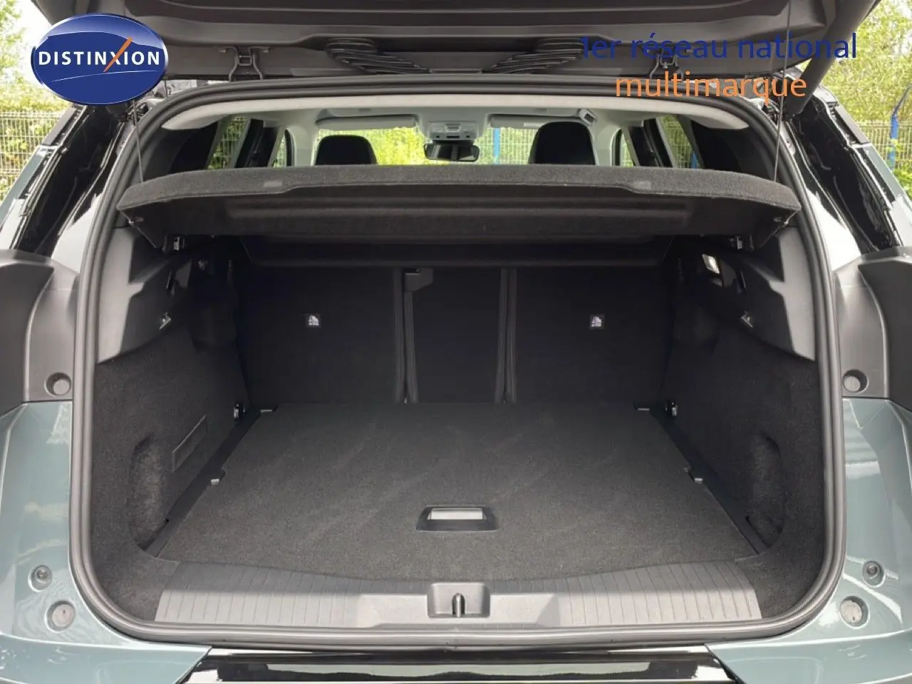 Coffre ouvert vu de l'arrière d'un Citroën C5 Aircross 2026 vert Astoria métal, espace de chargement spacieux et propre.