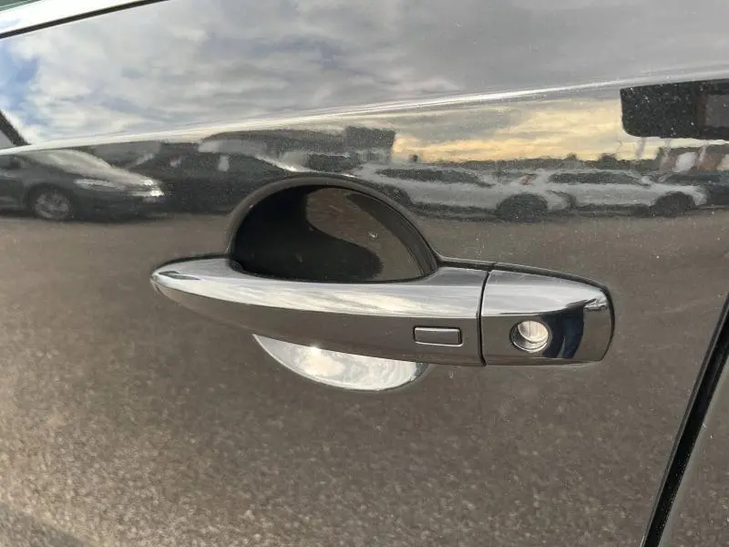 Poignée de porte noire Kuro métallisé côté gauche du Nissan Qashqai e-POWER 2024 avec bouton d'ouverture sans clé.