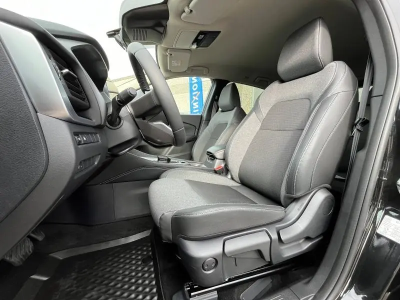 Intérieur avant droit du Nissan Qashqai e-POWER 2024 noir Kuro, sièges mixte TEP/tissu gris et noir, volant cuir multifonction.