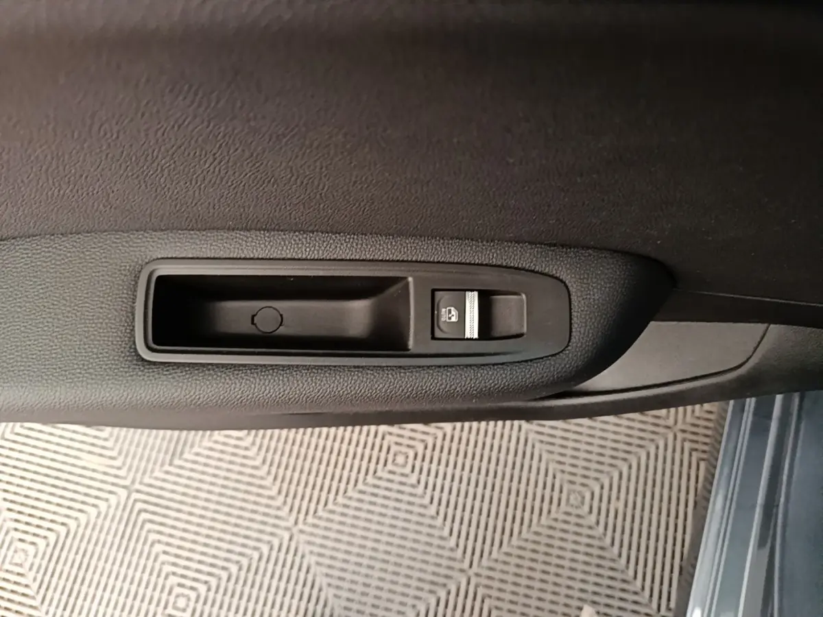 Détail de la commande de lève-vitre électrique sur la porte côté conducteur d’une Renault Clio Intens gris foncé 2020.