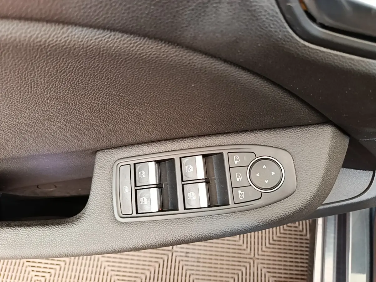 Commande des vitres électriques et réglage des rétroviseurs sur la porte côté conducteur d'une Renault Clio gris foncé 2020.