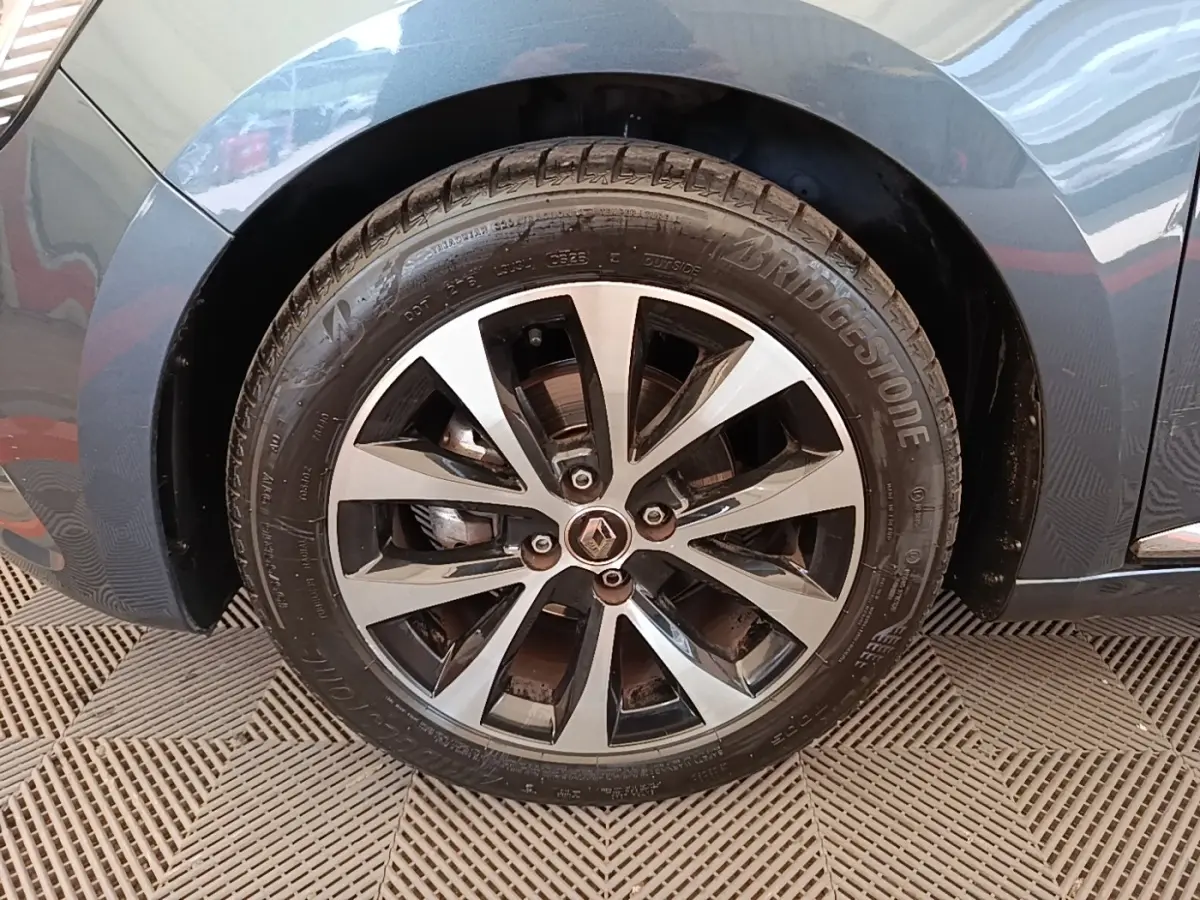 Gros plan sur la roue avant droite gris foncé d'une Renault Clio Intens TCe 100 avec jante alliage bicolore.