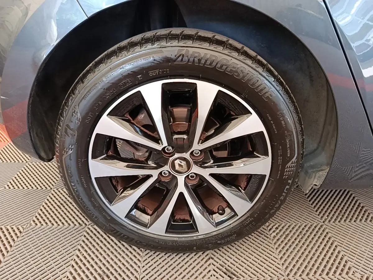 Gros plan sur la roue avant droite de la Renault Clio Intens TCe 100 gris foncé avec jante alliage bicolore.