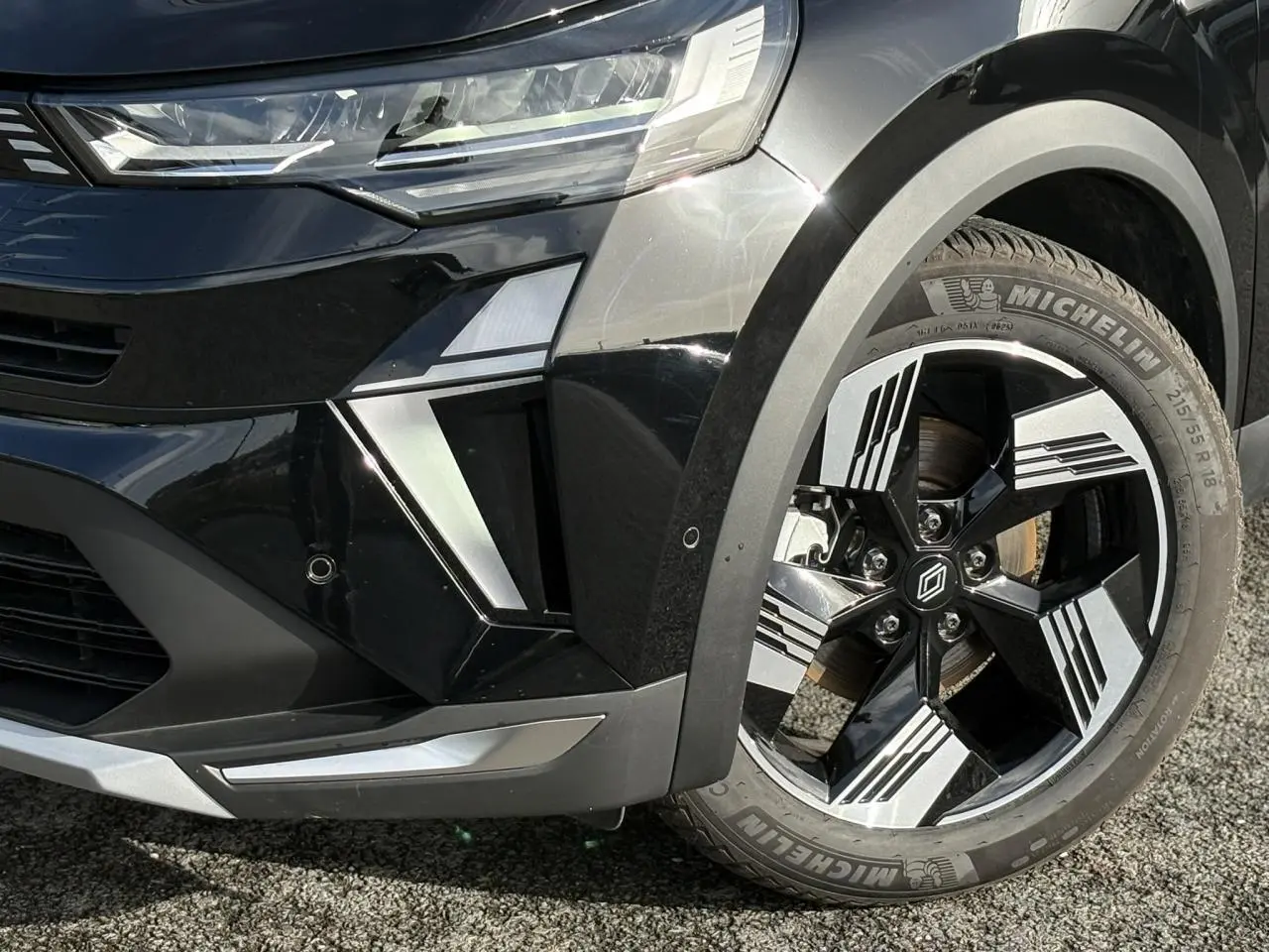 Gros plan sur la roue avant droite et le pare-chocs avant noir étoilé du Renault Symbioz 2025 avec jante 18 pouces Gravity.
