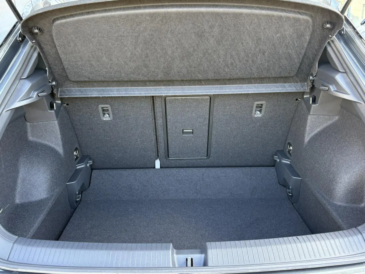 Vue intérieure du coffre spacieux et propre du Volkswagen T-Roc 2025, revêtement gris foncé uniforme.