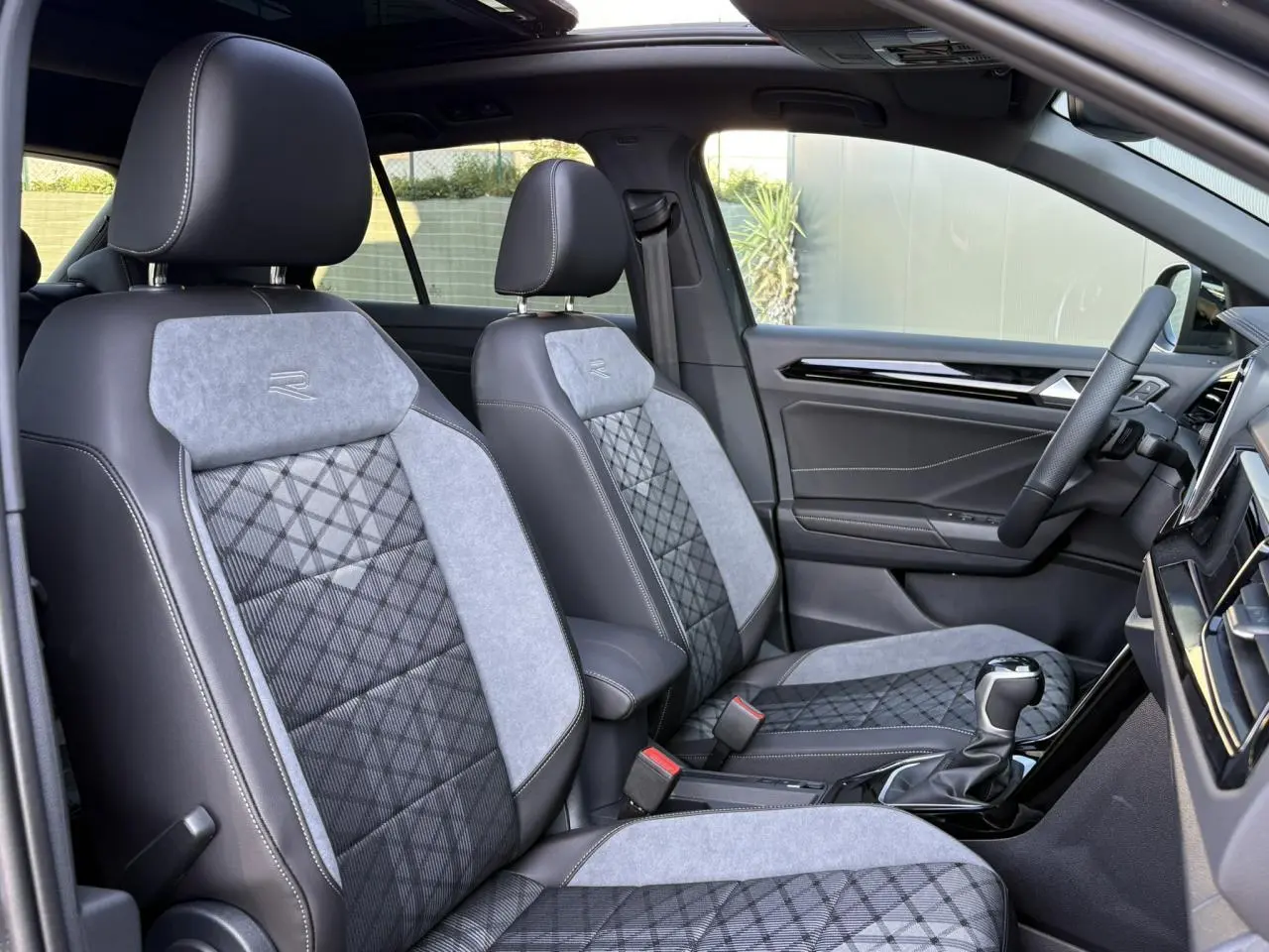 Vue intérieure côté droit du Volkswagen T-Roc 2.0 TDI R-Line 2025, sièges sport gris avec logo R brodé.