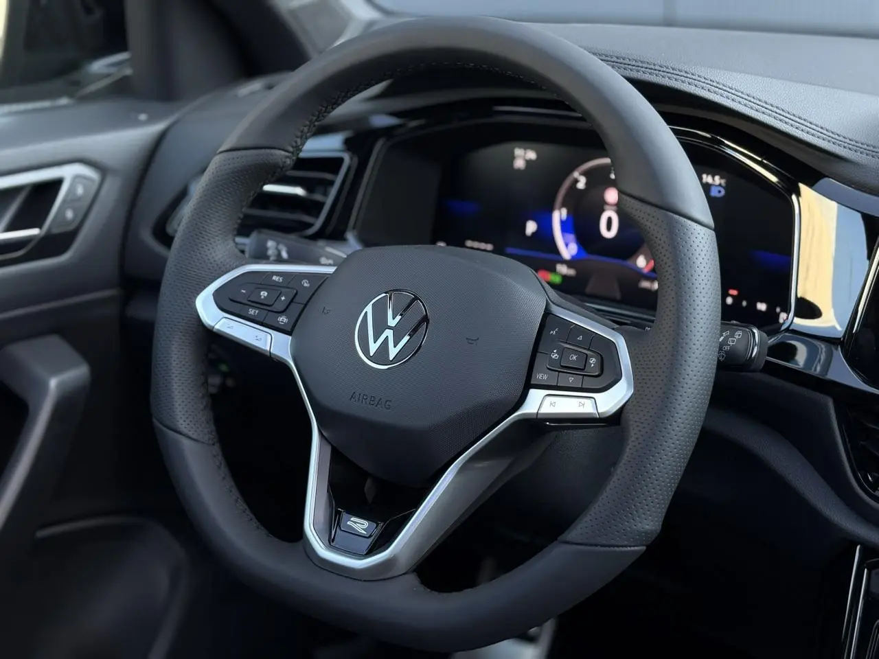 Volant sport multifonction en cuir avec logo R-Line de la Volkswagen T-Roc 2025, vue rapprochée côté conducteur.